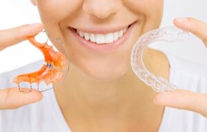 Person holding up two retainers, one in each hand.